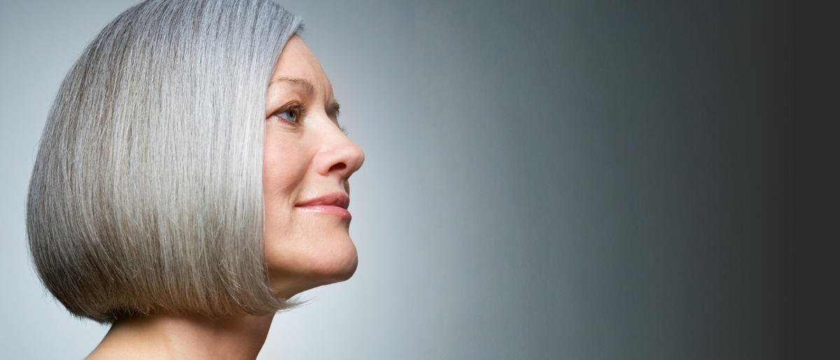 Woman with a stylish haircut against a gray background